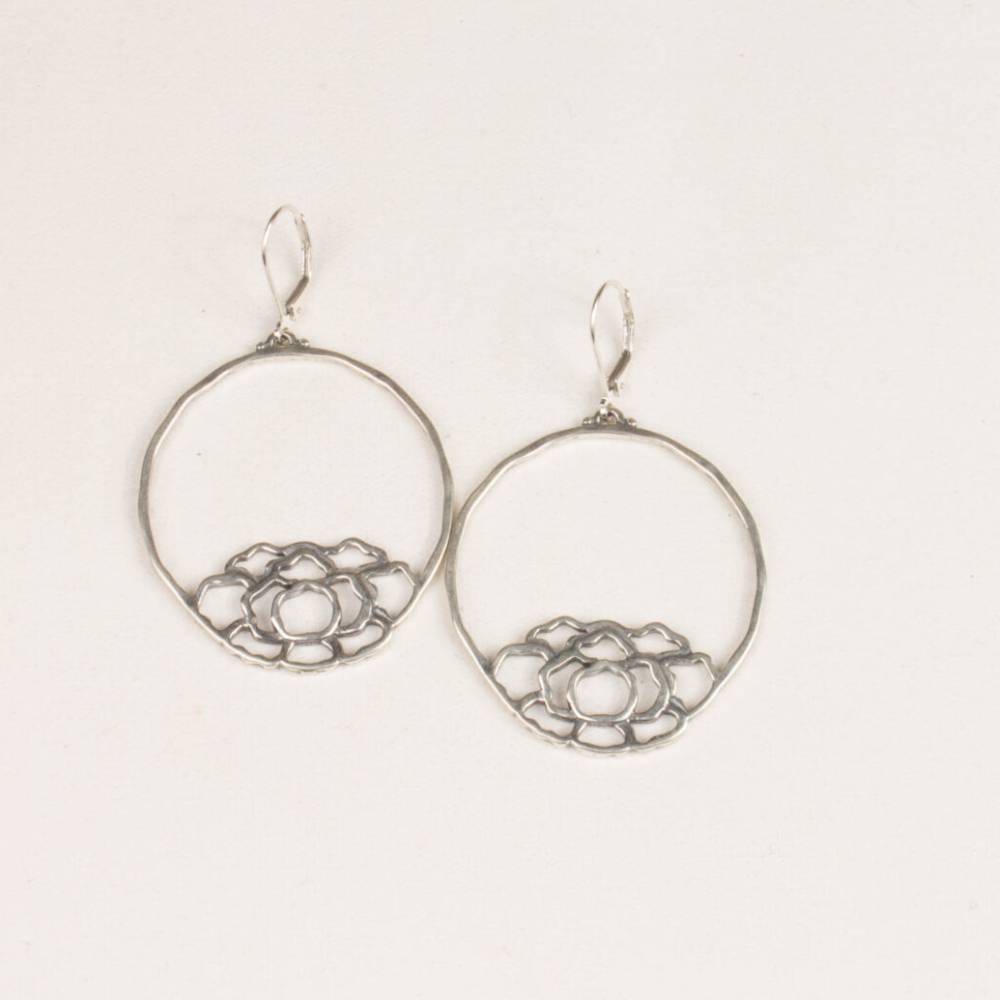 A pair of silver earrings with circles on them.