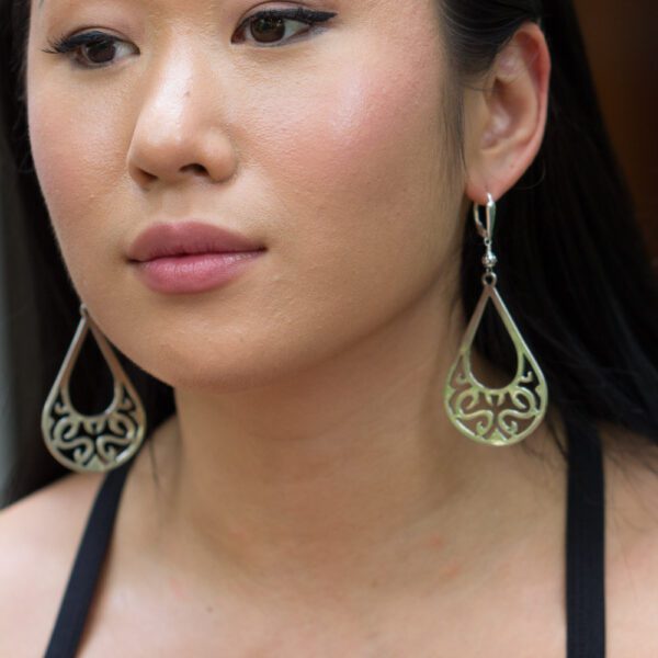 A woman with long hair wearing earrings.