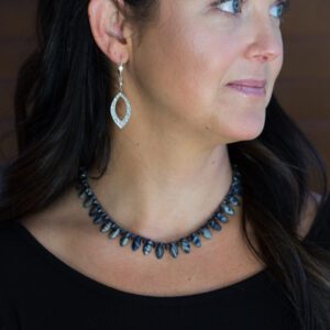 A woman wearing a necklace and earrings.