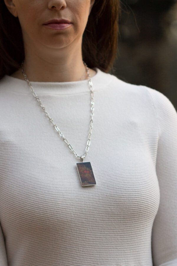 A woman wearing a white shirt and necklace.