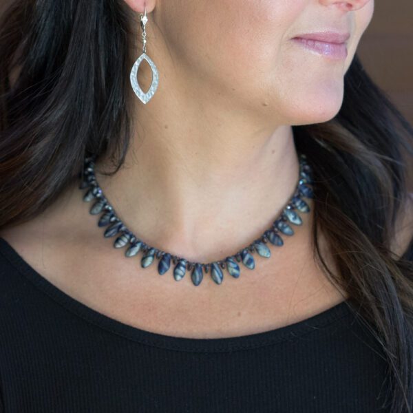 A woman wearing a necklace and earrings.