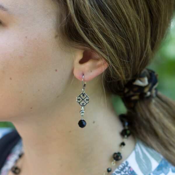 A woman wearing earrings and a necklace.