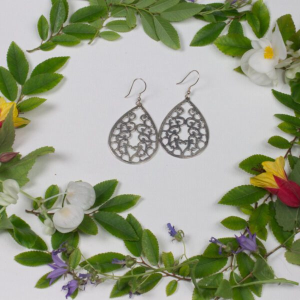 A pair of earrings sitting in the middle of a wreath.