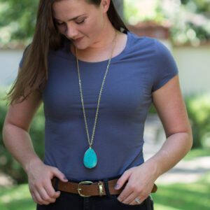 A woman wearing a blue shirt and brown belt