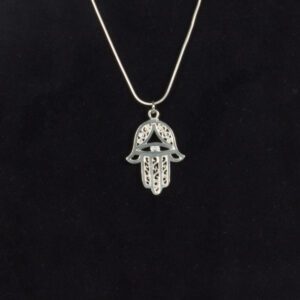 A silver necklace with an image of a hamsa hand.