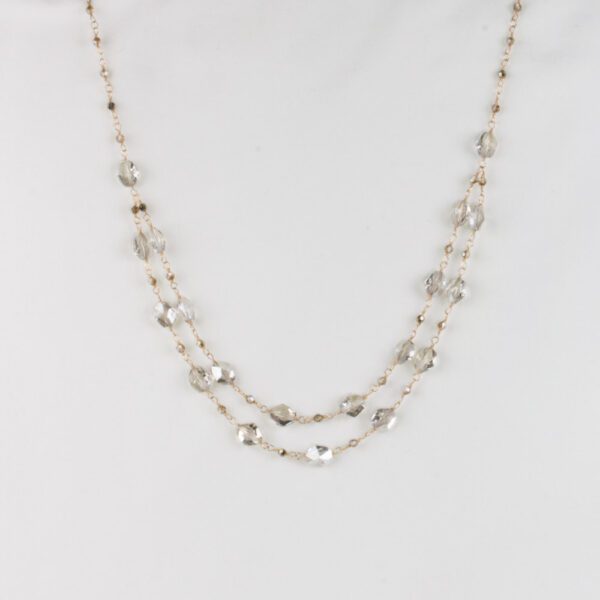 A long necklace with silver beads and chains.