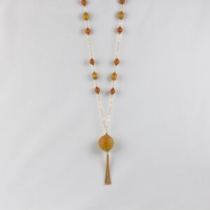 A long necklace with an orange bead and tassel.