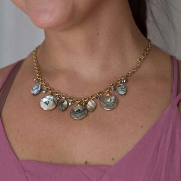 A woman wearing a necklace with shells on it.