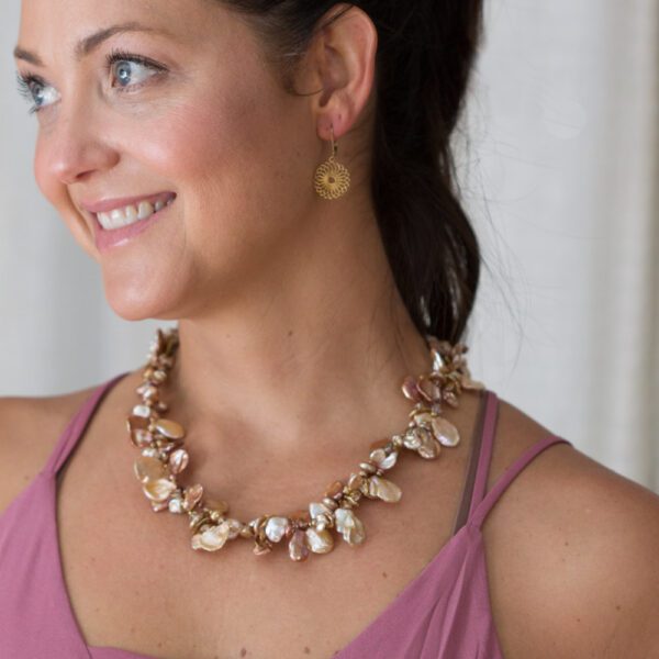 A woman wearing a necklace and earrings.