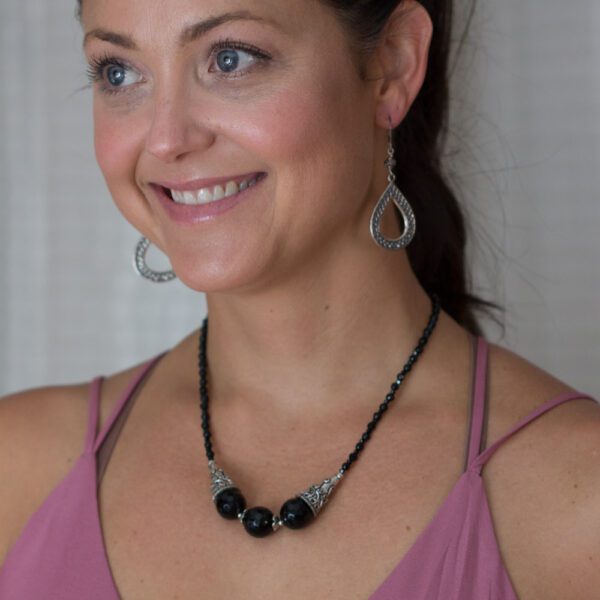 A woman wearing a necklace and earrings.