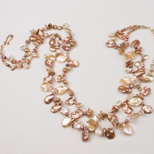 A long necklace with pink pearls and gold beads.