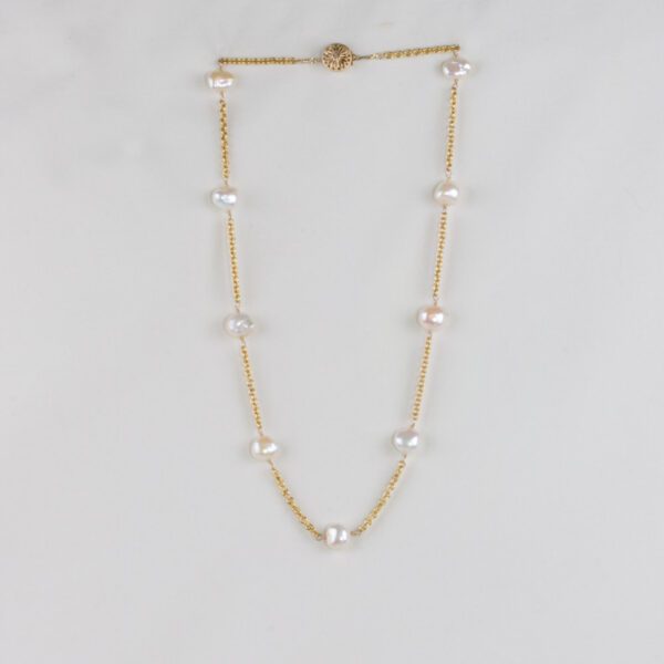 A gold chain with pearls on it