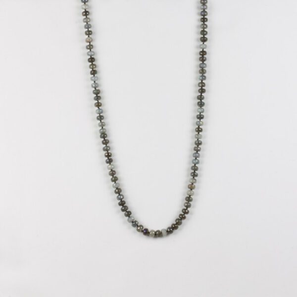 A long necklace with a silver chain and black beads.