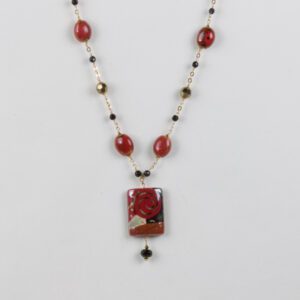 A necklace with red and black beads on it