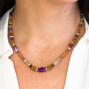 A woman wearing a necklace with colorful beads.