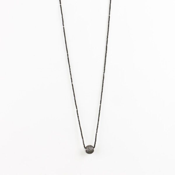 A black necklace with a small ball on it.