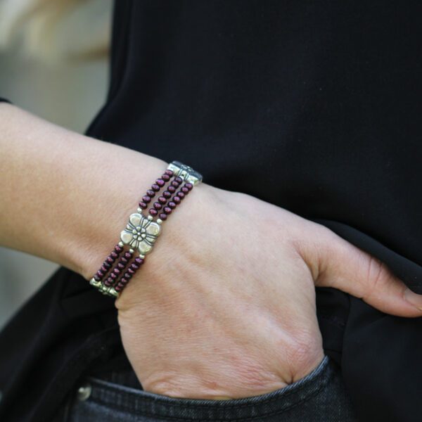 A woman wearing a bracelet with two rows of beads.