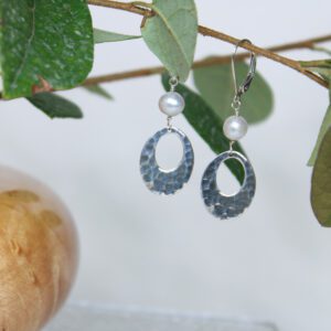 Sterling silver oval earrings with oval cutout and white pearl on top.