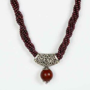 A necklace with a red bead and silver beads.